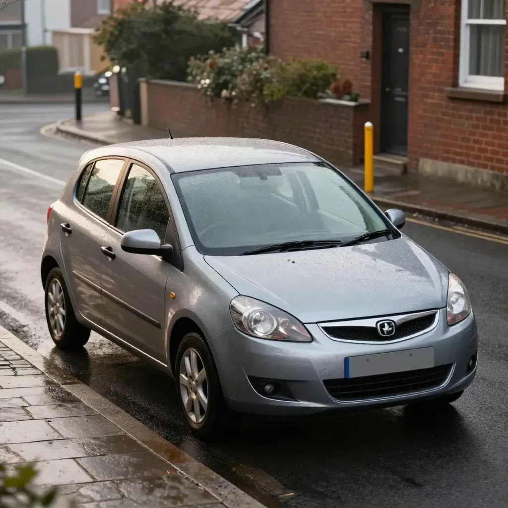 Manual learner hatchback climbing a wet residential hill after a smooth hill start.